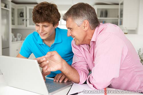 Parent helping teen with drivers ed.